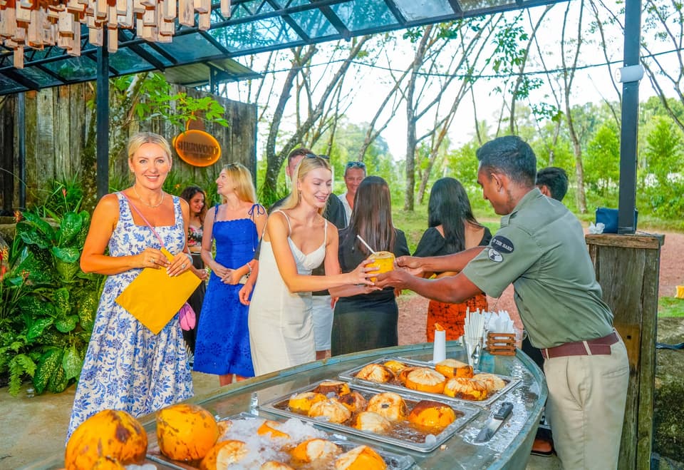 Guests gathered around fresh king coconut drinks and traditional Sri Lankan food
