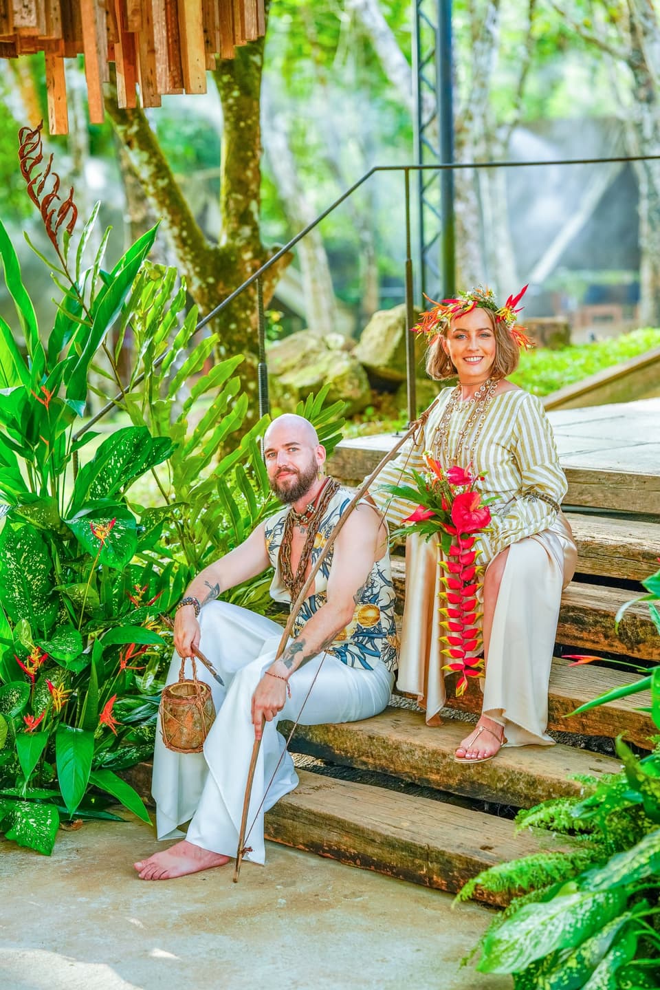 Couple in traditional dress posing for a timeless portrait on rustic wooden steps