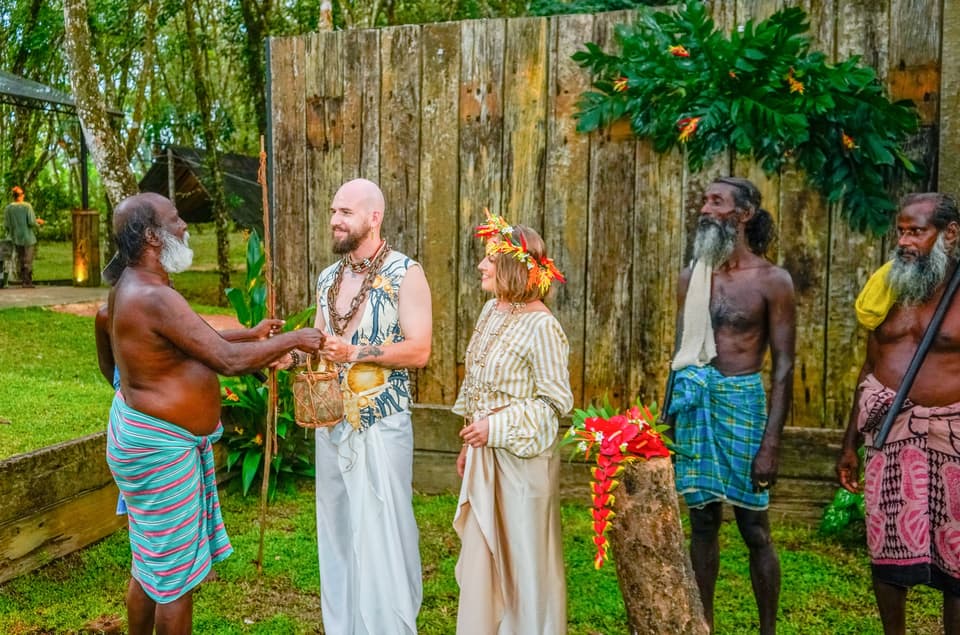 A community elder offering a woven basket gift to the couple during the ceremony